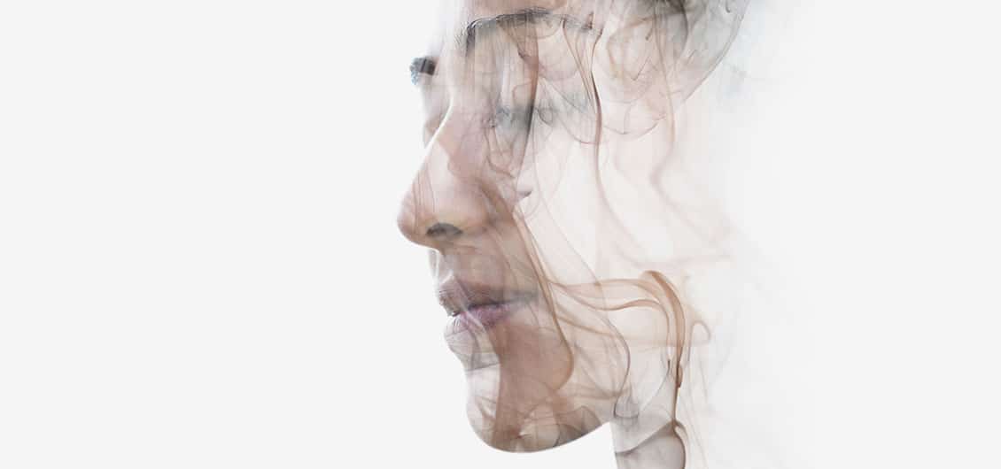 Face of a woman in smoky double exposure