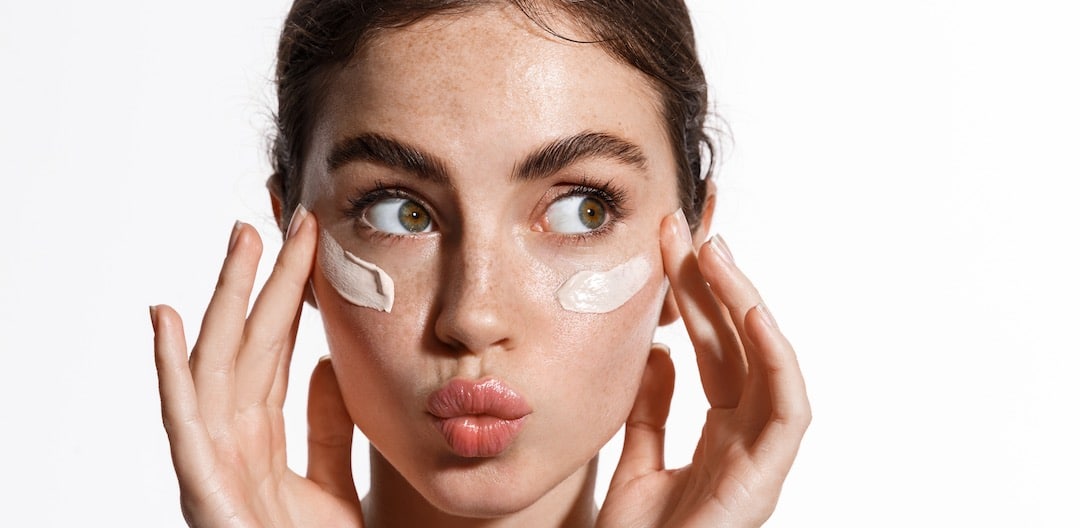 Close Up Beauty Girl With Freckles and Thick Eyebrows Applying Makeup