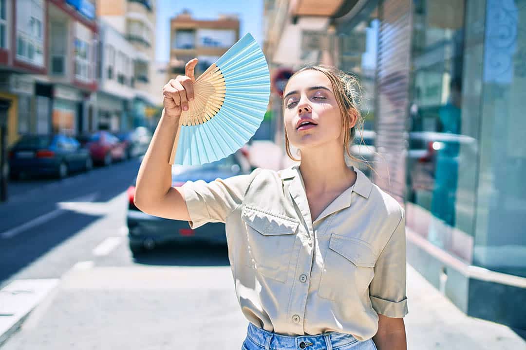 Young woman fanning herself in the sun