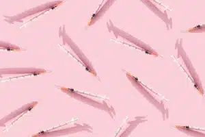 Lots of syringes on a pink background