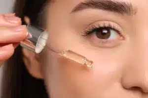 Woman applying skin care product to her cheek