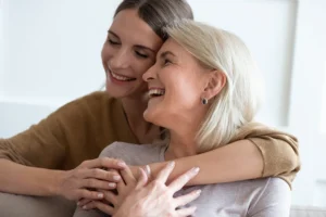 Mother and daughter smiling and hugging