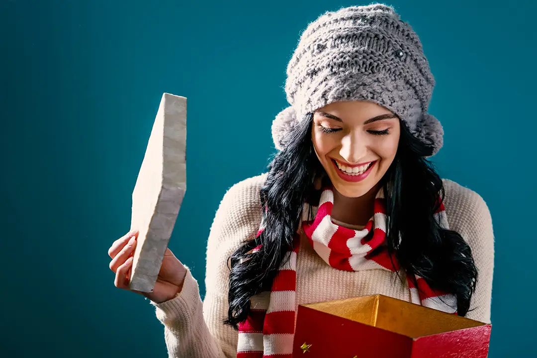 Beautifully Curated Kits They’ll Love Opening Woman opening a Christmas gift box