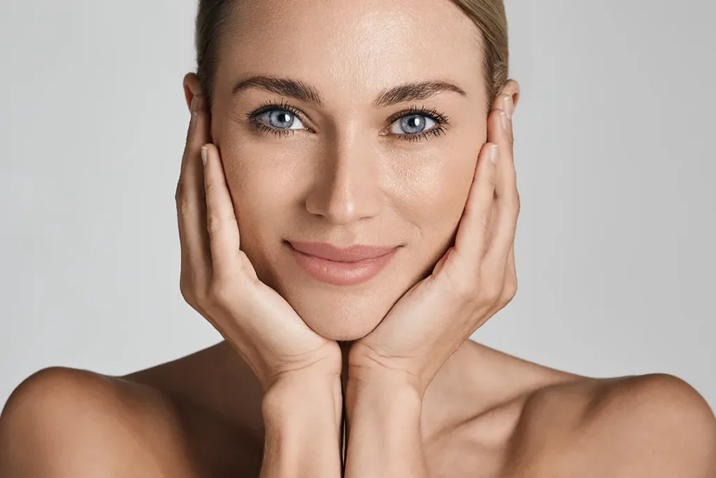 Smiling woman with her hands holding her face